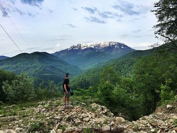 Rear view of man on mountain against sky