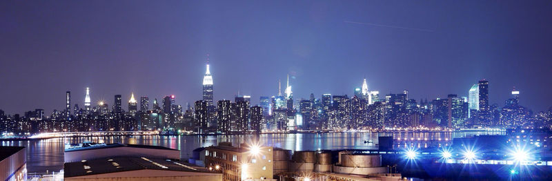 Illuminated buildings in ne york city against sky at night