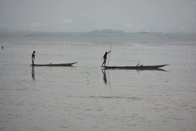 People on boat against sky