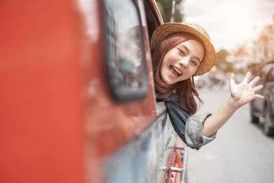 Young woman standing in a car