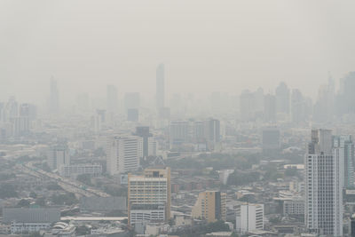 Aerial view of buildings in city against sky