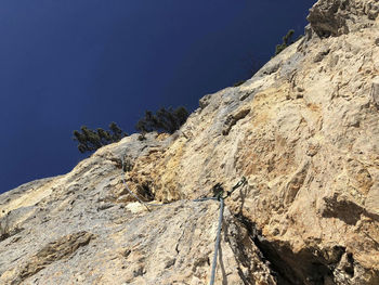 Low angle view of rocky mountains against clear sky