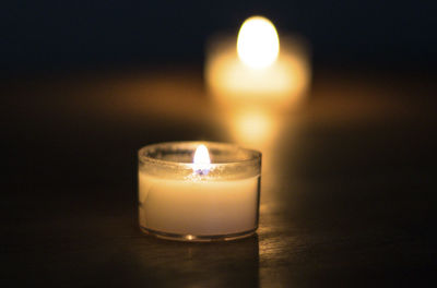 Close-up of illuminated tea light candle on table
