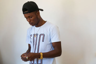 Young man standing against wall