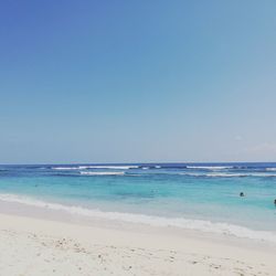 Scenic view of beach against clear blue sky