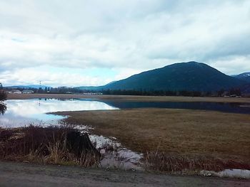 Scenic view of lake against cloudy sky