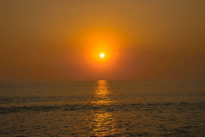 Scenic view of sea against orange sky