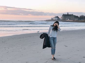 Full length of young woman standing on beach