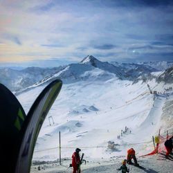 People on snowcapped mountain against sky