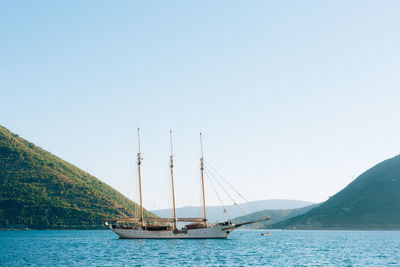 Sailboats sailing on sea against clear sky