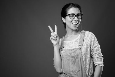 Smiling woman standing against black background