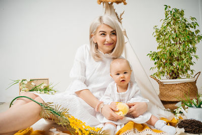 Portrait of smiling young woman holding christmas tree