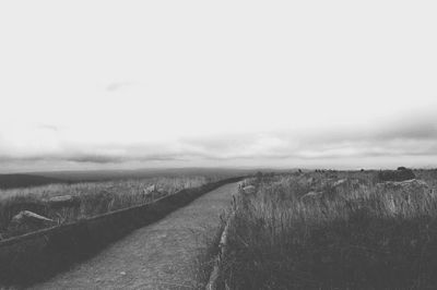 Road amidst field against sky