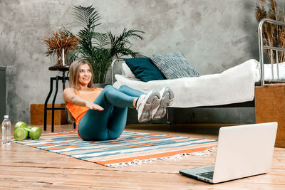 Young woman using phone while sitting on table