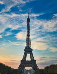 Low angle view of eiffel tower against cloudy sky