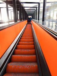 Rear view of woman on escalator