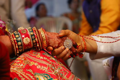 Cropped image of couple holding hands during wedding ceremony