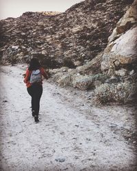 Rear view of woman walking on mountain