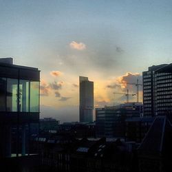 Buildings against cloudy sky at sunset