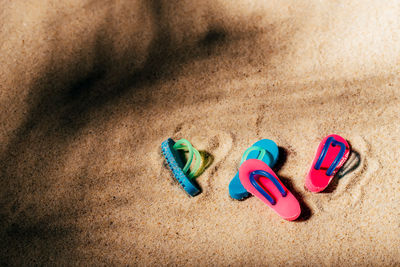 High angle view of multi colored shoes on sand