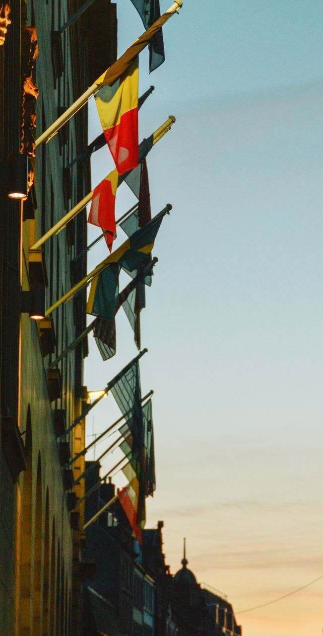 LOW ANGLE VIEW OF FLAGS HANGING FROM BUILDING