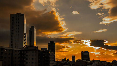 Modern buildings against sky during sunset