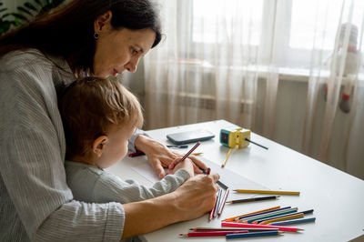 Side view of woman working at home