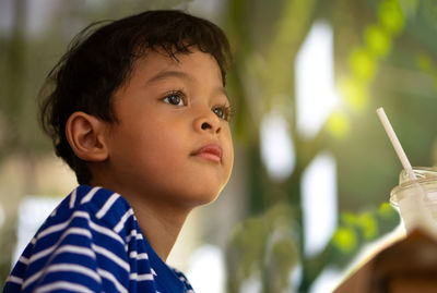 Close-up portrait of cute boy looking away