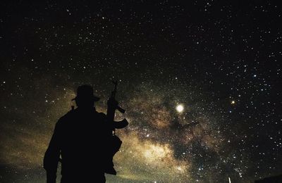 Silhouette man standing against sky at night