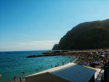 People on beach against blue sky