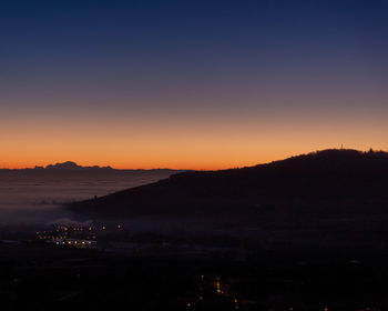 Scenic view of silhouette mountains against sky at sunset