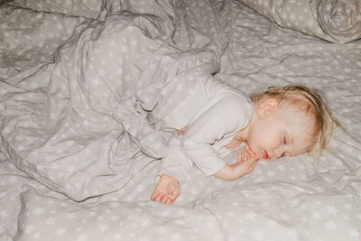 High angle view of baby sleeping on bed