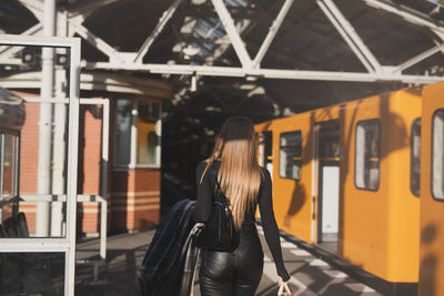 Rear view of woman standing in train