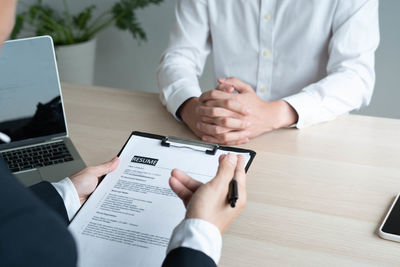 Midsection of man using laptop on table