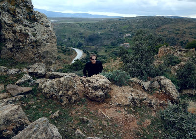 Rear view of man standing on rock