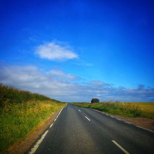 Empty road along countryside landscape