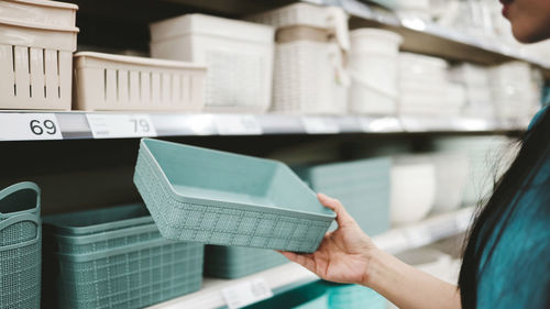 Midsection of woman holding container at store