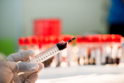 Cropped hand of doctor holding syringe at hospital