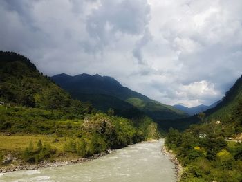 Road amidst plants and mountains against sky