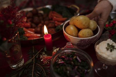 High angle view of hands holding bowl with boiled potatoes