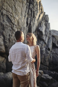 Rear view of couple walking on rock