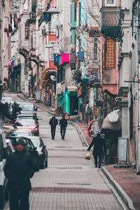 People walking on street amidst buildings in city