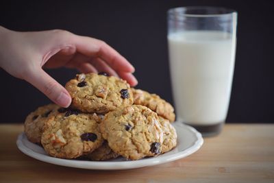Cropped hand having cookie at home