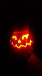 Close-up of illuminated pumpkin against black background