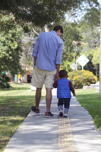 Man and boy walking on footpath