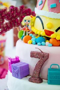 Close-up of number seven candle and a birthday cake.