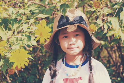 Portrait of cute girl standing against plants