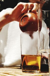 Close-up of hand holding beer glass