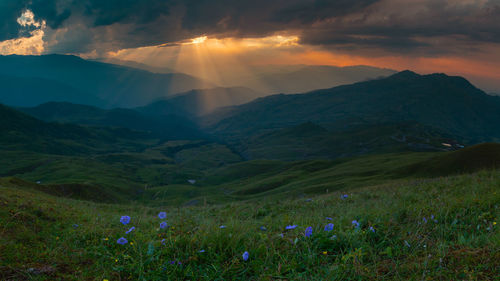 Sunset in the mountains and thunderstorm, the sun's rays shine through the clouds