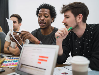 People looking at camera while sitting on table